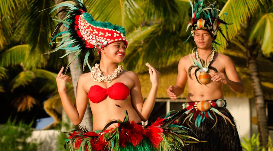 Ballerini polinesiani in costumi colorati sulla spiaggia