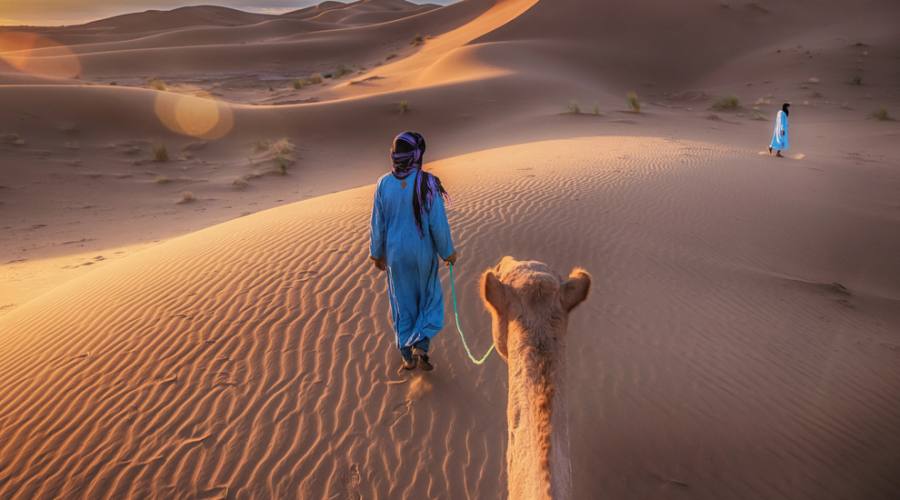 Due nomadi tuareg che guidano un cammello nel deserto del Sahara